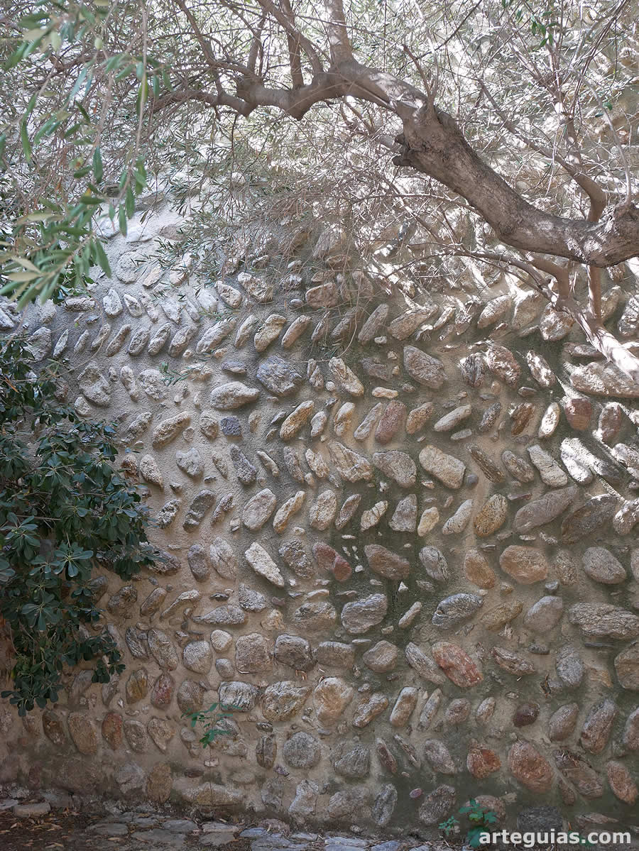Muro de la cabecera con cantos rodados dispuestos en forma de espina de pez