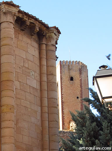 Iglesia rom&aacute;nica de Santa Clara con una de las torres del castillo al fondo