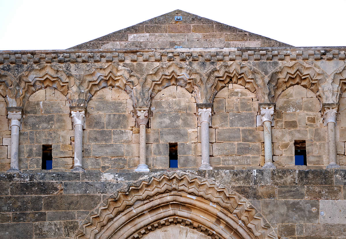 Arcos con chevrons sobre columnas de la fachada