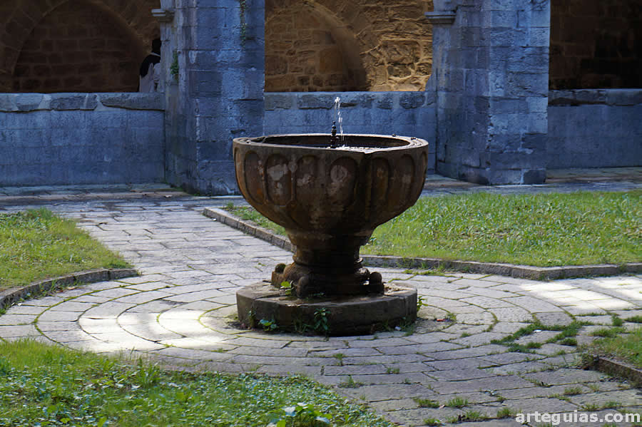 Una pila bautismal en el centro del claustro de la colegiata