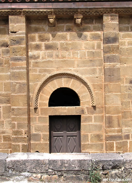 Puerta de la iglesia en el muro del sur. Aunque el guardapolvos es ajedrezado, t&iacute;pico del rom&aacute;nico, se aprecia una simplicidad propia del prerrom&aacute;nico