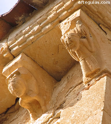 Canecillos que muestran a un hombre con un barril y un contorsionista