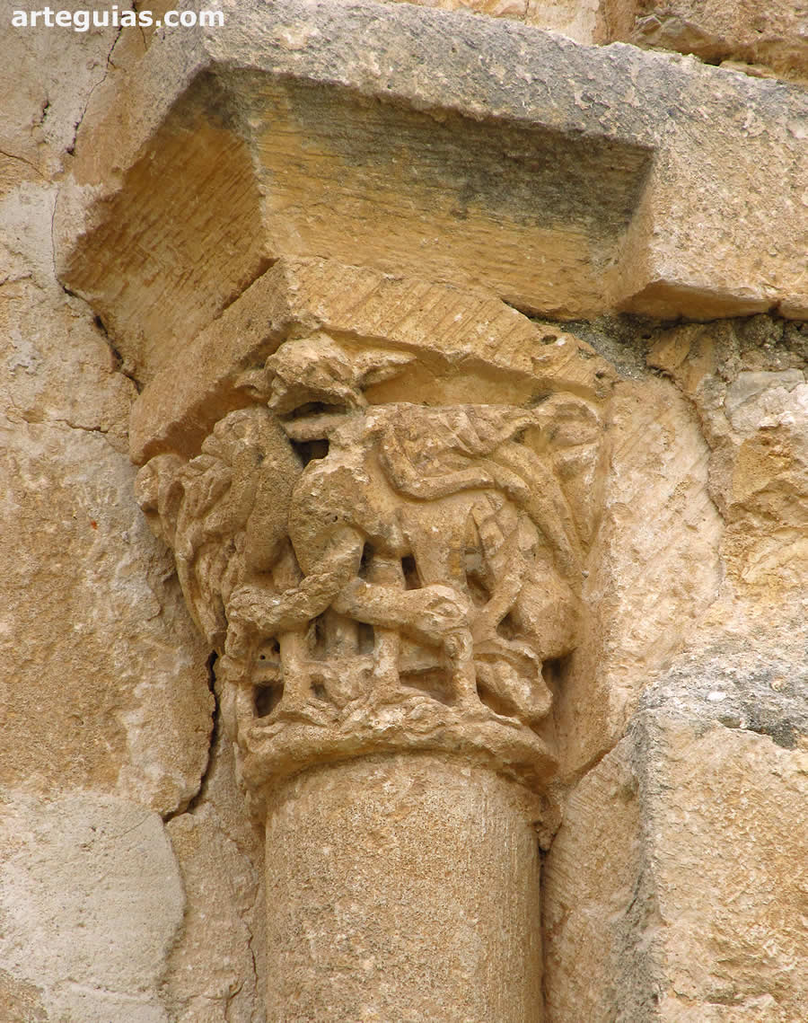 Capitel de aves picando sus patas con las cabezas entrelazadas