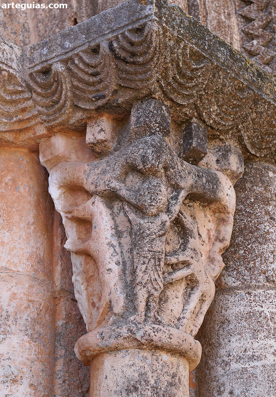 Capitel de la puerta con varios leones y una figura humana