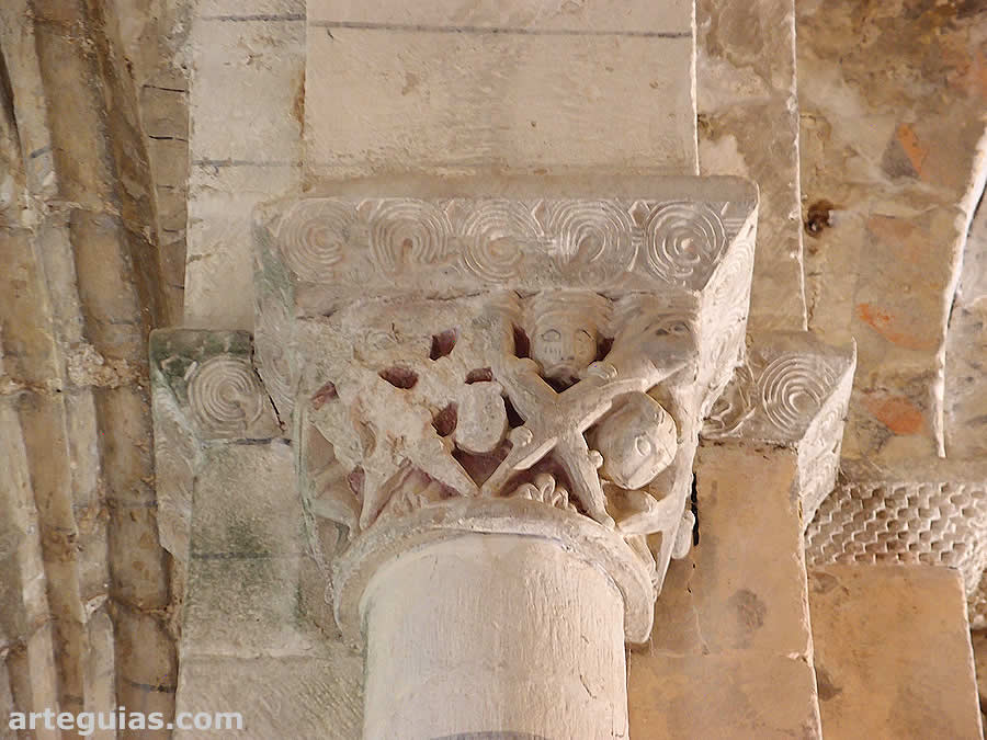 Capitel con figuras en aspa y cabeza humanas y animales