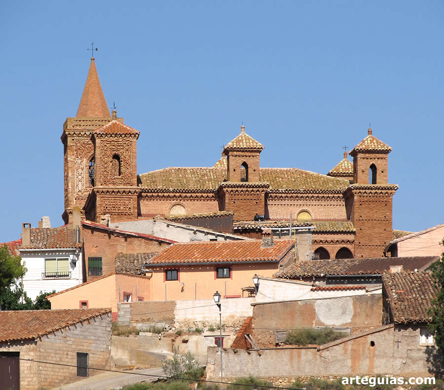 Imagen de la iglesia de Torralba de Ribota desde el sur sobresaliendo del caser&iacute;o de la localidad