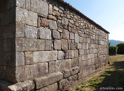 Muro sur de la iglesia de San Xes con algunas hiladas de sillares originales y otros recolocados